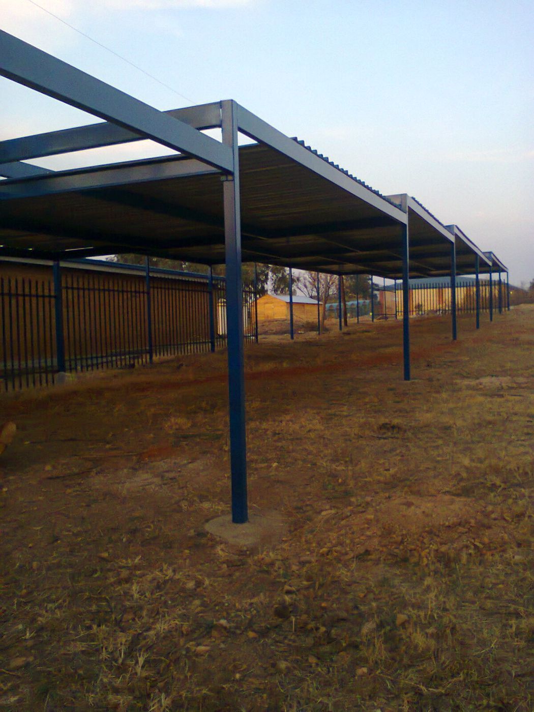 A long row of carports on blue steel columns